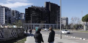 VALENCIA, 28/02/2024.- Unas personas observan el exterior del edificio que sufrió un incendio en el barrio de Campanar de Valencia el pasado jueves, en el que murieron diez personas. El Gobierno valenciano ha modificado el presupuesto de la Generalitat Valenciana de este ejercicio con el fin de incluir dos nuevas líneas de subvención de concesión directa para ayudar a las personas afectadas el incendio por un importe global de 3.450.000 euros. EFE/ Kai Försterling