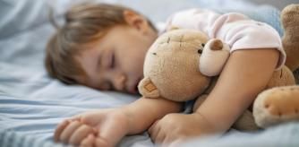 Un bebé durmiendo con su peluche.