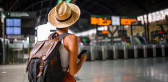 Una persona con su equpaje de mano a punto de coger el tren.