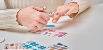 Una mujer haciéndose la manicura con pegatinas para uñas