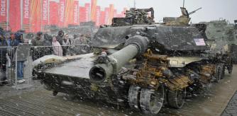 People visit an exhibition showing western military equipment captured by Russian forces in Ukraine, displayed at the WWII memorial complex at Poklonnaya Hill in western Moscow during a snowfall on May 8, 2024. (Photo by Natalia KOLESNIKOVA / AFP)