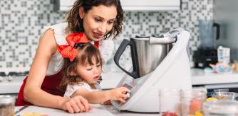 Madre e hija cocinando con un robot de cocina.