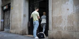 FOTO MARTI GELABERT 17/05/2024 EN LA CALLE ROGER DE LLURIA, ENTRE LOS NUMEROS 16, 128 Y 130, SE OFRECEN APARTAMENTOS DE ALQUILER TURISTICO ILEGAL. UNA MUJER SE ENCARGA DE HACER EL CHECK-IN A UNO DE LOS TURISTAS QUE HA RESERVADO EL ALOJAMIENTO