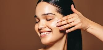 Una mujer aplicándose crema hidratante facial