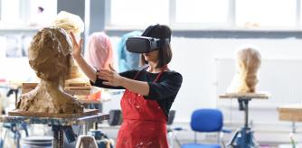 Una mujer moldeando una figura con gafas de realidad virtual.