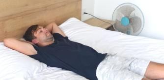 Hombre durmiendo con un ventilador en marcha