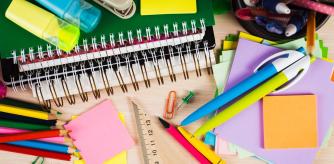 Accesorios escolares y de oficina en fondo de madera.