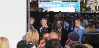 Puigdemont, justo en el momento en que bajó a la parte de atrás de la tribuna tras su discurso, una zona que la organización impedía fotografiar y en la que se ve a los voluntarios con los sombreros entre los que se camuflaron