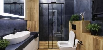 Un baño de estilo moderno con la mampara negra y las paredes azules