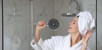 Mujer en la ducha cogiendo la alcachofa.