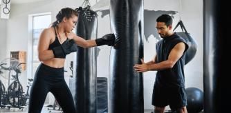 Una chica entrenando en un saco de boxeo.