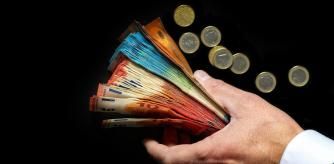Un hombre sosteniendo un fajo de billetes de euro