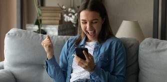 Una mujer viendo el móvil con entusiasmo