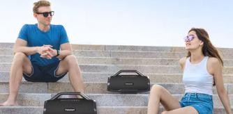 Una pareja escucha música en la calle con un altavoz Tronsmart