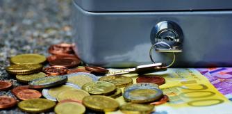 Imagen de recurso: una caja fuerte junto a varios billetes y monedas