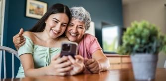 Madre e hija mirando el móvil con felicidad