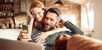 Una pareja sonríe ante el descubrimiento de las mejores ofertas en Amazon