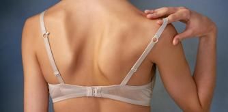 Una mujer tocándose la tira del sujetador