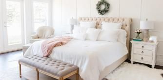 Dormitorio en tonos claros con cabecero tapizado con capitoné