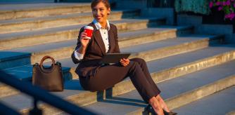 Una mujer sentada en una escalera con el bolso al lado