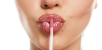 Una mujer con un labial de maquillaje en los labios