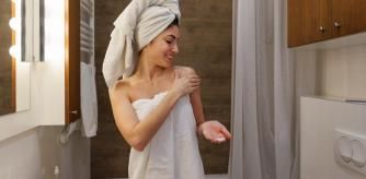Una mujer se aplica una crema hidratante al salir de la ducha