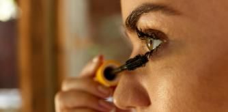 Una mujer se aplica la máscara de pestañas