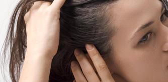 Una chica enseña las canas que le han salido