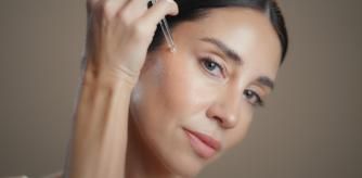 Una mujer poniéndose sérum en el rostro