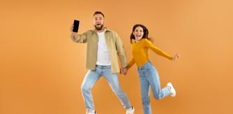 Pareja saltando con el móvil