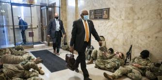 Washington (United States), 13/01/2021.- Majority Whip James Clyburn (R) walks past members of the National Guard trying to get some sleep inside the US Capitol in Washington, DC, USA, 13 January 2021. Democrats hope to impeach the president a second time for incitement of insurrection following the attack on the Capitol last week as lawmakers worked to certify Joe Biden as the next President of the United States. (Atentado, Estados Unidos) EFE/EPA/JIM LO SCALZO