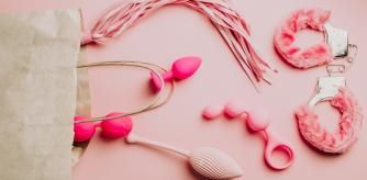 Sex toys and accessories on pink background. Flat lay