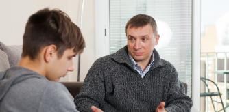 Father soothes teenager son after quarrel