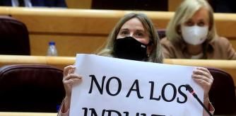 La senadora del PP, Cristina Ayala, enseñó al ministro de Justicia carteles contra los indultos, durante la sesión de control al Gobierno