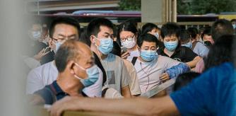BEIJING, CHINA - AUGUST 27: Commuters wait in line for public buses as they leave work in the business district on August 27, 2021 in Beijing, China. China's Supreme People's Court ruled this week that its illegal for companies to subject employees to the practice known as 996