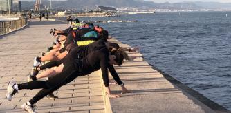 Clase dirigida de tonificación en el rompeolas del Port Olímpic.
