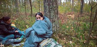 Mujeres y niños migrantes tras cruzar la frontera de Bielorrusia a Polonia en el bosque cerca de Michalowo, el pasado 6 de octubre (NurPhoto / Getty)