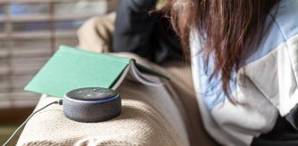 Mujer sentada en el sofá con un Echo Dot