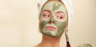 Rutina de cuidado de piel, mujer aplicándose una mascarilla facial