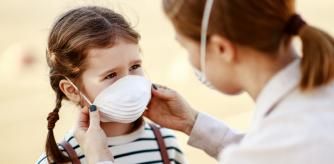 From above adult woman putting on medical mask of little girl while standing on city street during coronavirus pandemic
Mascarillas para niños: opciones, trucos y modelos básicos o de colores que podemos elegir