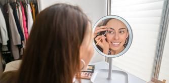 Mujer maquillándose a través del espejo