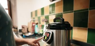 Una mujer programando una olla de cocción lenta