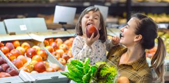 Una niña comiendo una manzana junto a su madre