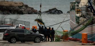 Los forenses desembarcan el cuerpo de una de las víctimas