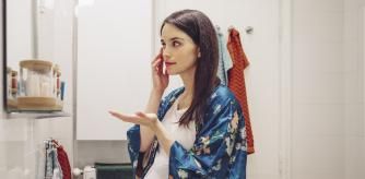 Mujer embarazada echándose una loción