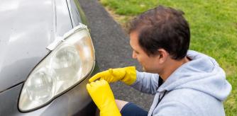 Un hombre se afana en mantener los faros de su coche