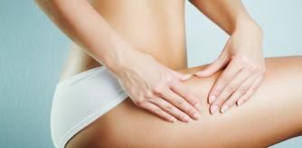 Youn woman squeezing leg to show no cellulite