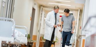 Hombre lesionado en una pierna consulta con un médico en un hospital