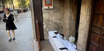 foto XAVIER CERVERA 23/09/2022 un homeless indigente vagabundo sintecho pernocta (con cartones mantas o colchoncito, sabana,.. y tambien un vaso para pedir limosna, asi como bolsa y agua) de manana en l entrada de un restaurante (yantar ribera) de la calle roger de flor, barcelona