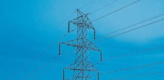 COSTES DE ENERGIA Y SUMINISTROS BÁSICOS.. UNA TORRE DE ELECTRICIDAD CON LA CIUDAD DE BARCELONA DE FONDO